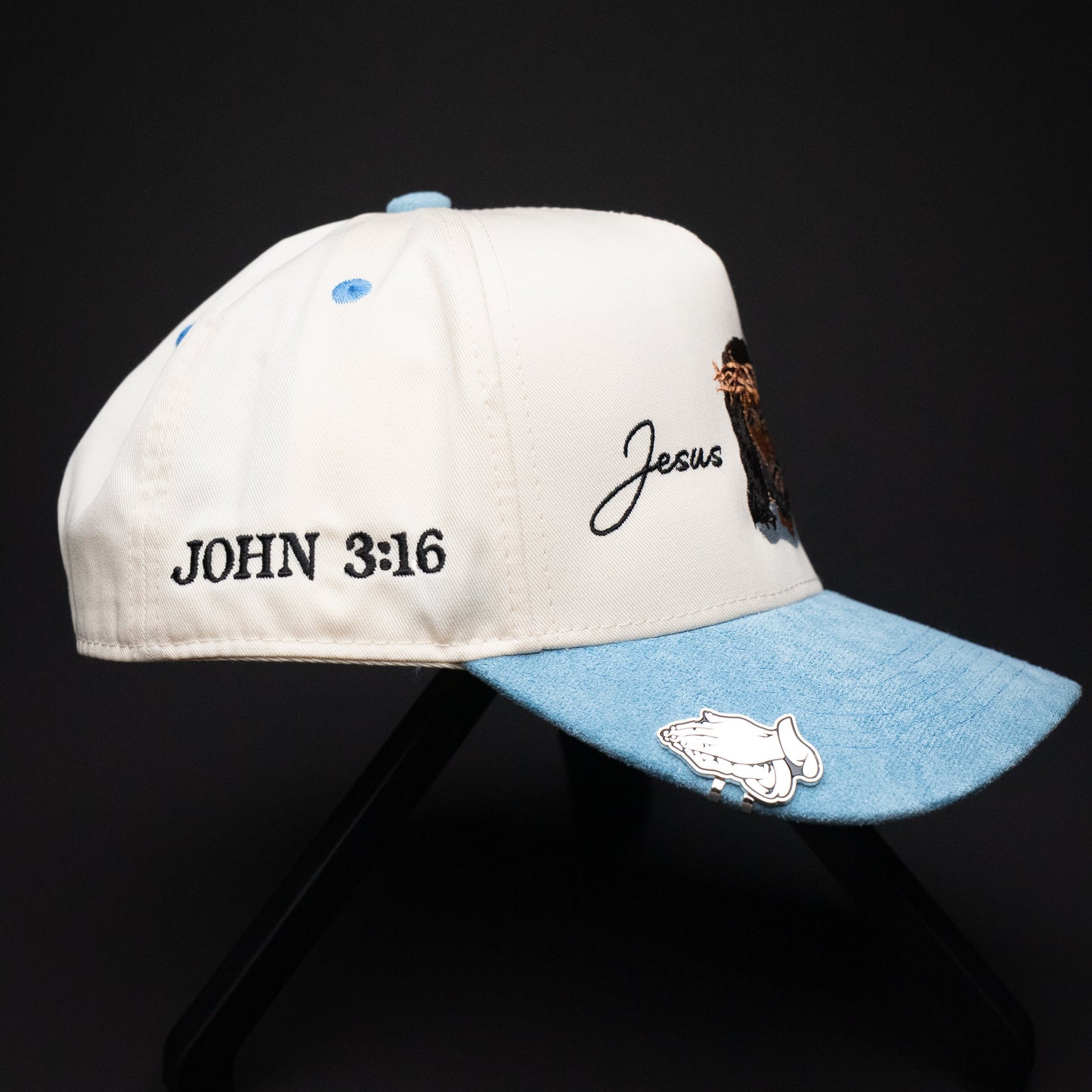 White and blue cap with 'John 3:16' and 'Jesus' text on a black background