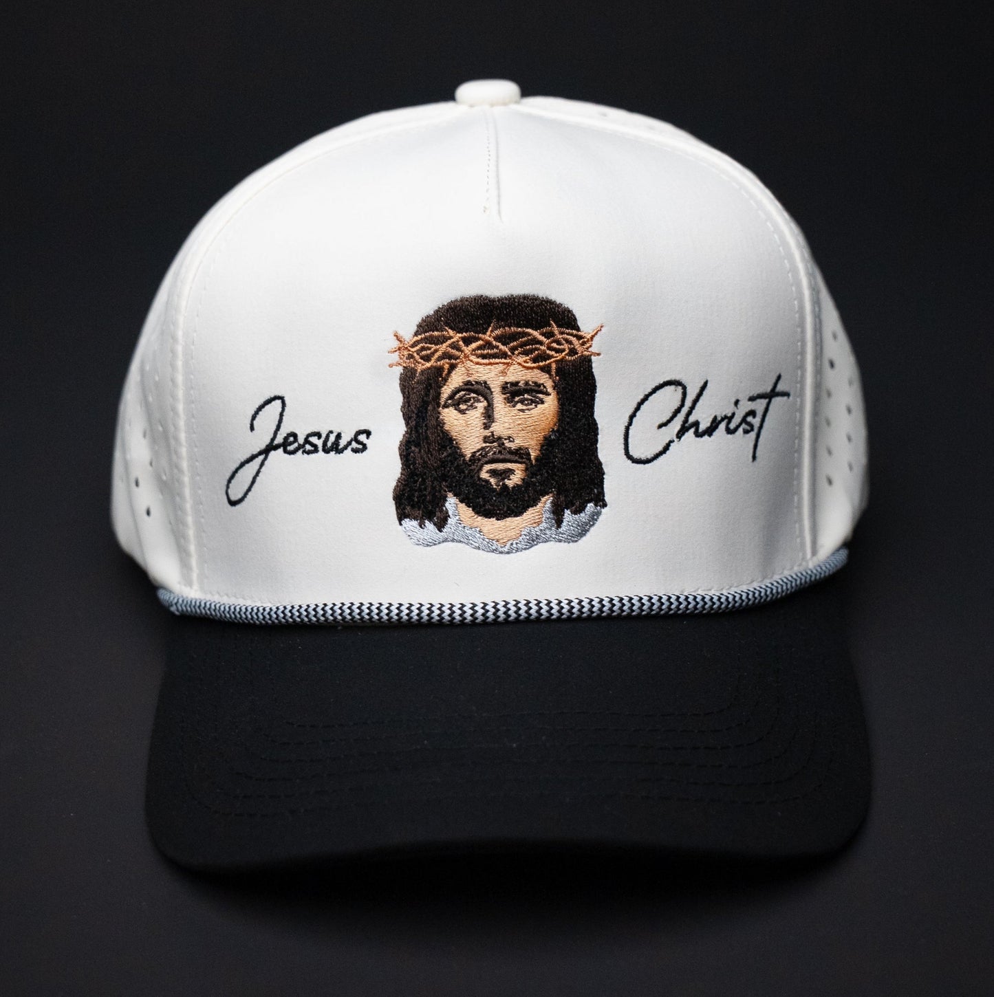 White cap with an embroidered design of Jesus Christ on a black background
