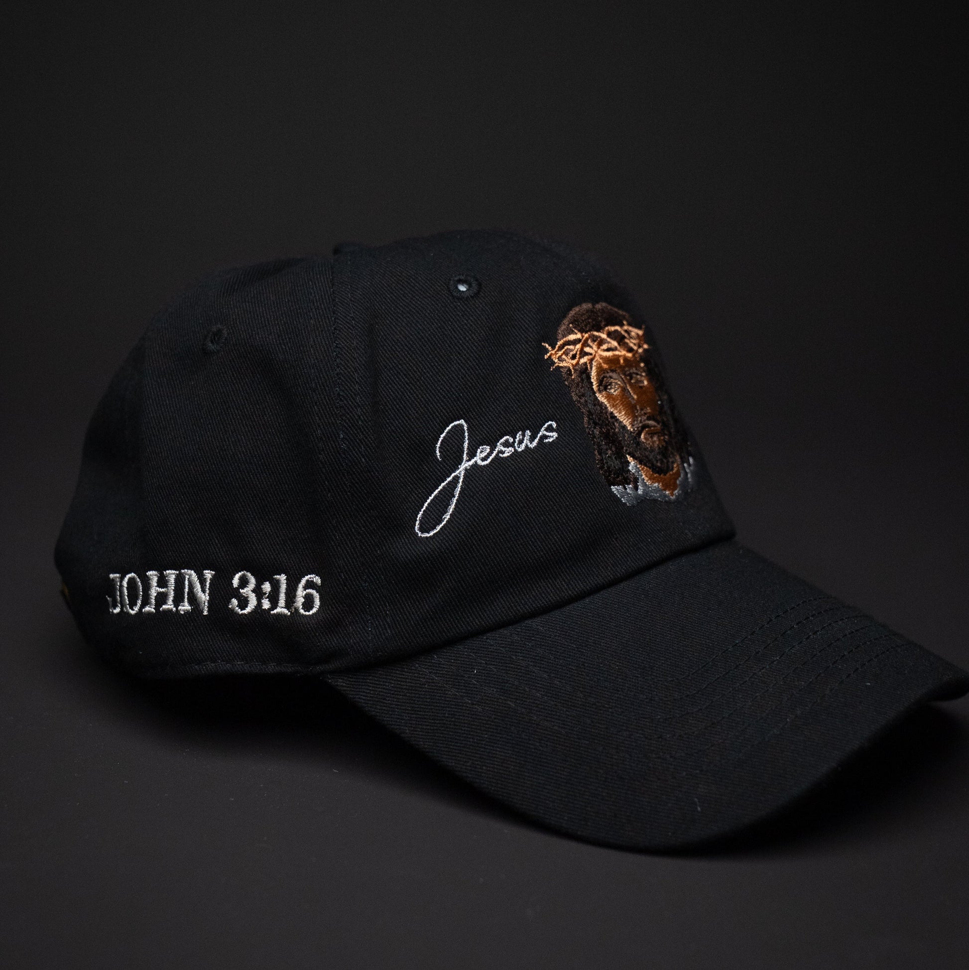 Black cap with 'Jesus' and 'John 3:16' text on a dark background