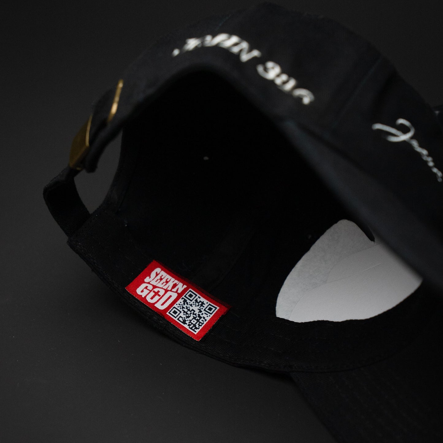 Black cap with a red label featuring a QR code on a dark background