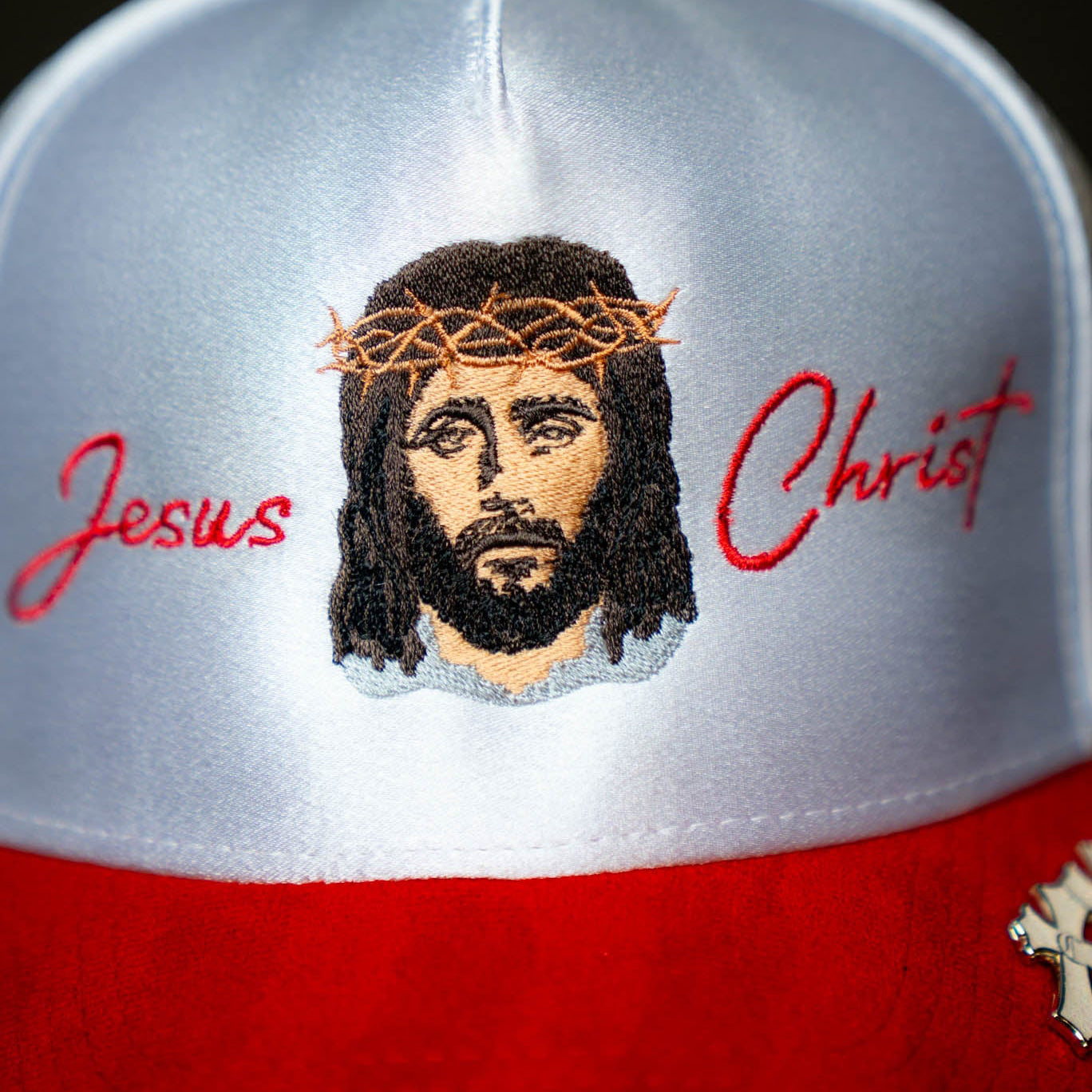 Cap with embroidered face of Jesus Christ and 'Jesus Christ' text on a black background
