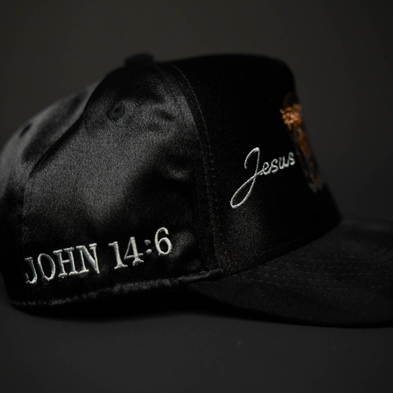 Black cap with 'John 14:6' and 'Jesus' embroidered on a dark background